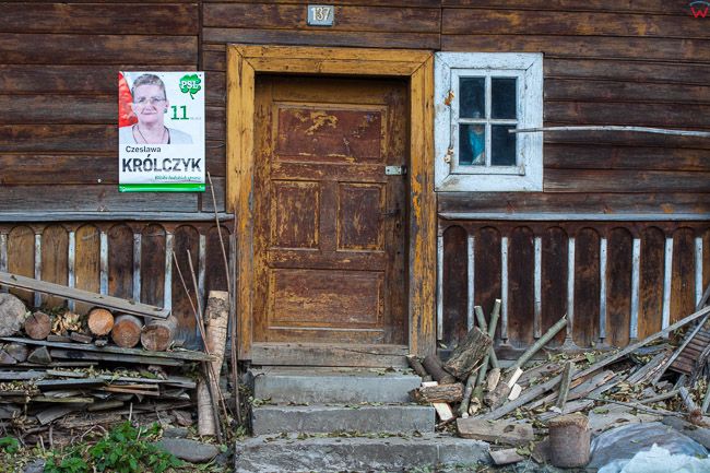 Ochotnica Gorna, drewniana zabudowa wsi z rozwieszonymi plakatami wyborczymi. EU, Pl, Malopolska.